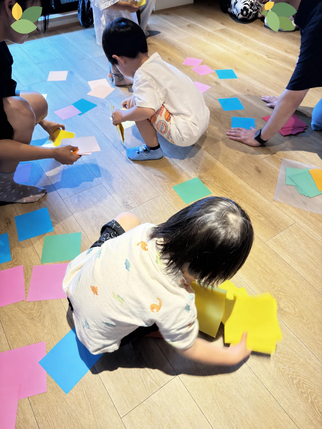 床に広げた色カードを親子で探す親子英語イベントの様子