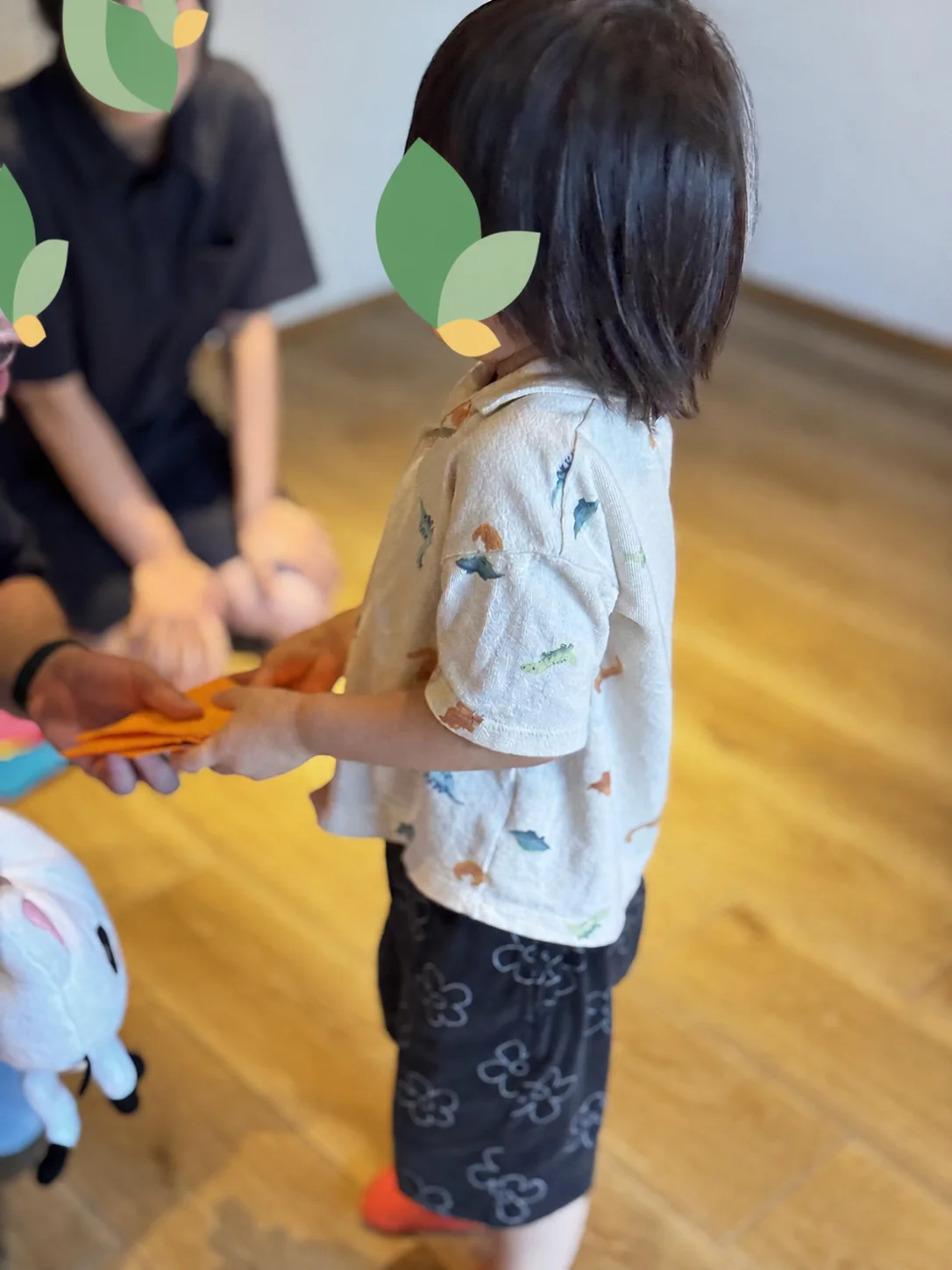 先生へオレンジ色のカードを手渡す親子英語イベントの活動